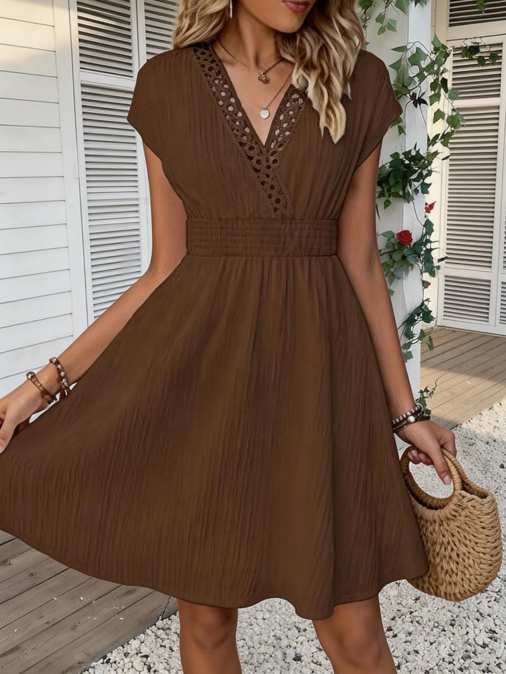 French lace V-neck fitted dress with waistline and short puff sleeves. Striped texture short skirt with vertical lines. Beach-st