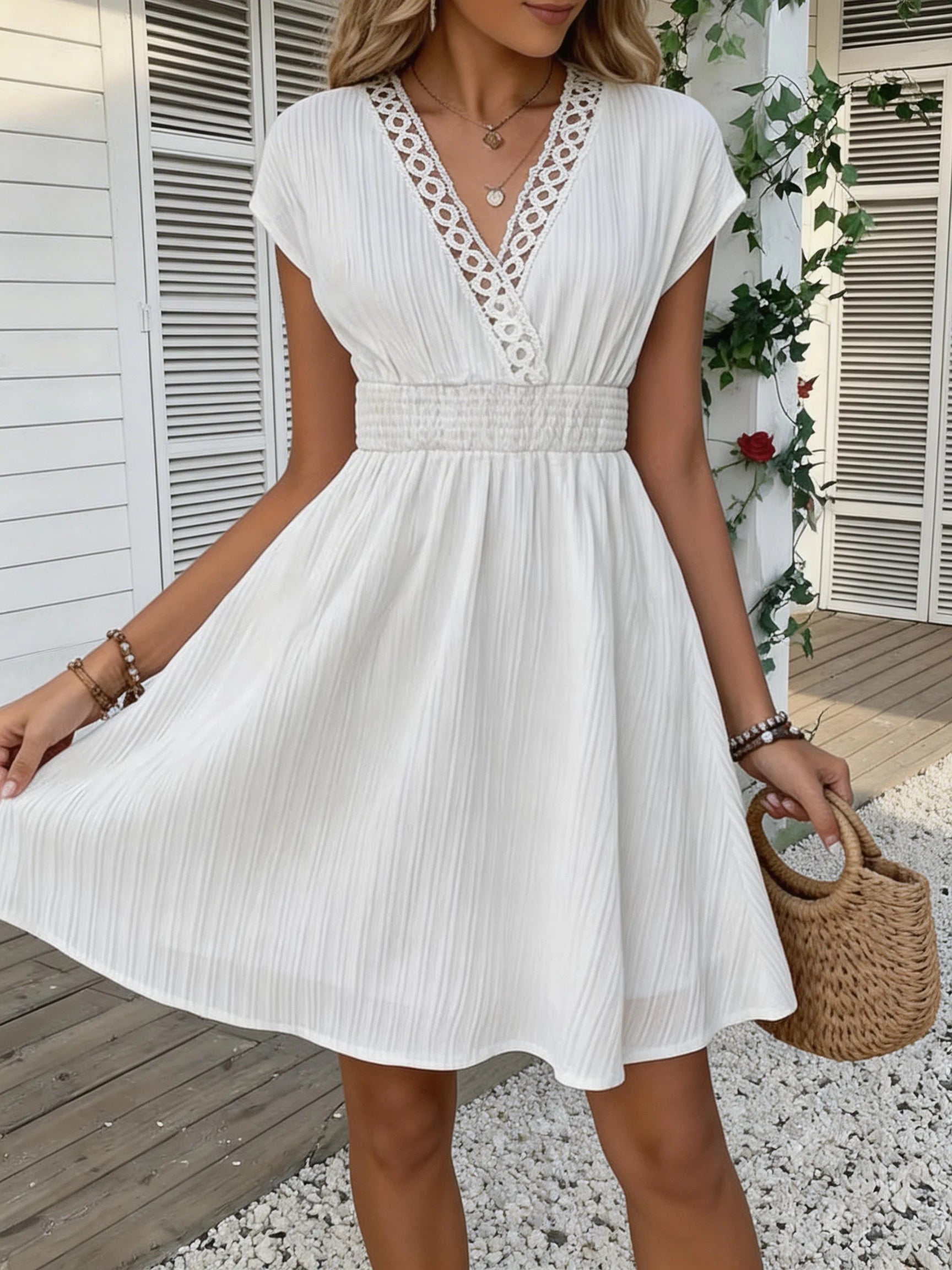 French lace V-neck fitted dress with waistline and short puff sleeves. Striped texture short skirt with vertical lines. Beach-st