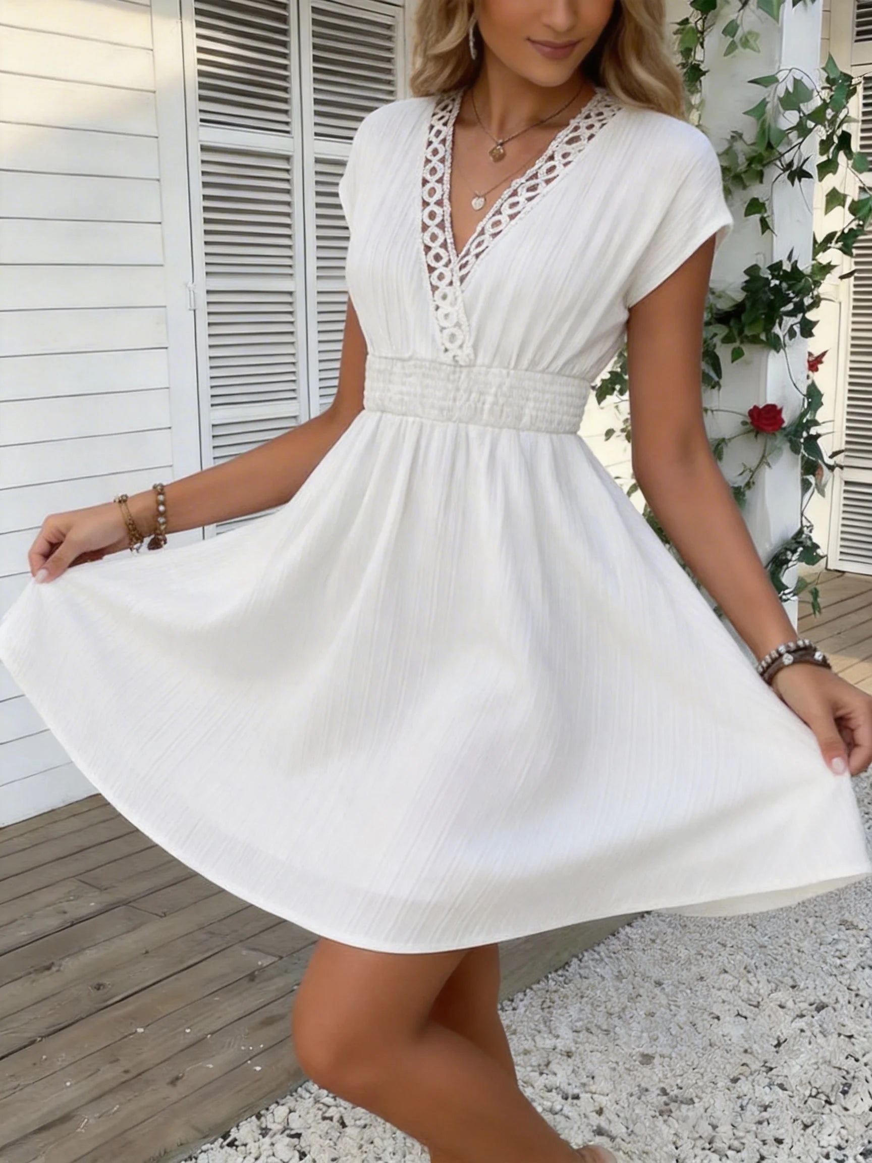 French lace V-neck fitted dress with waistline and short puff sleeves. Striped texture short skirt with vertical lines. Beach-st